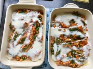 Lasagne assembly with white sauce on top of ragu.