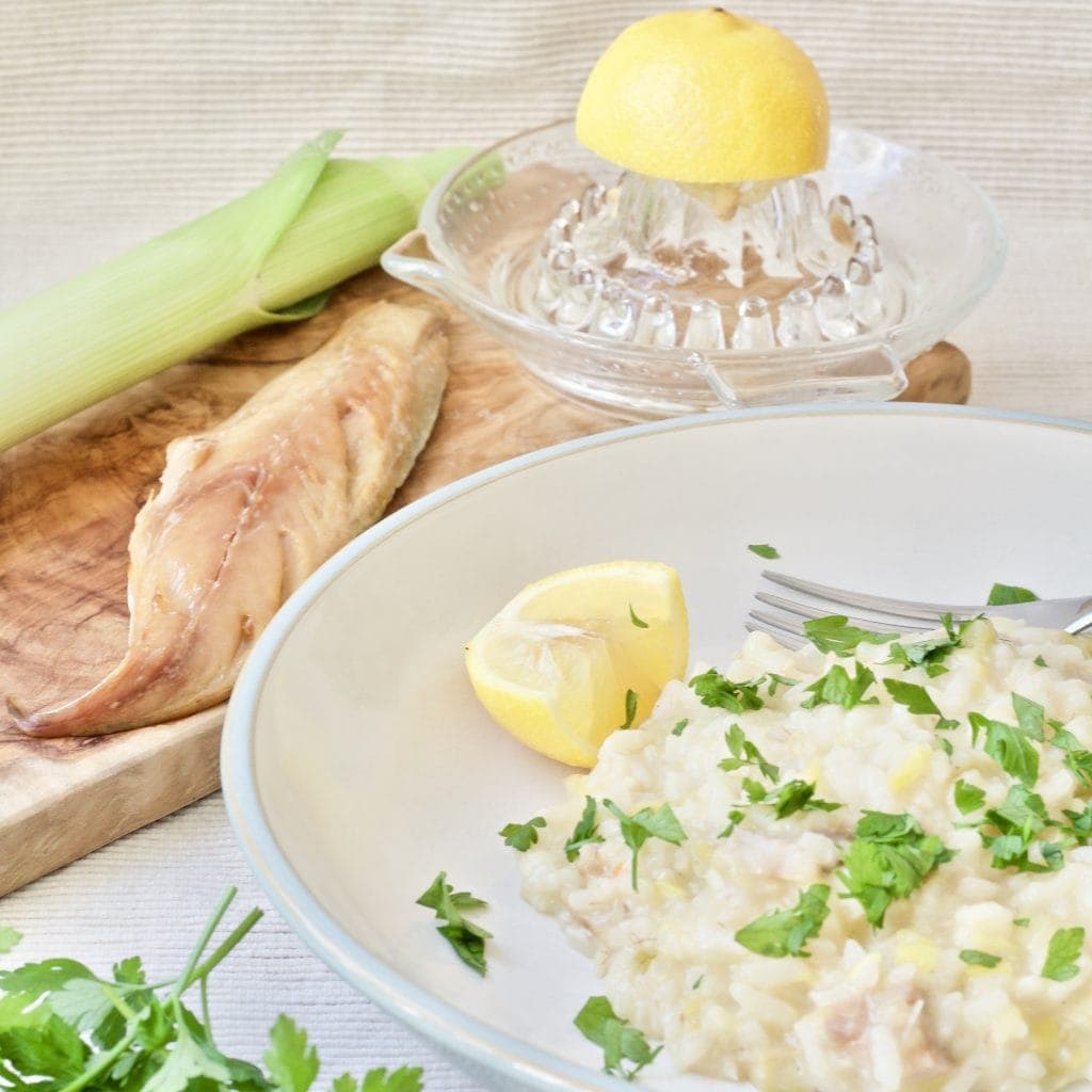 Risotto in a bowl with smoked mackerel, leek and lemon.