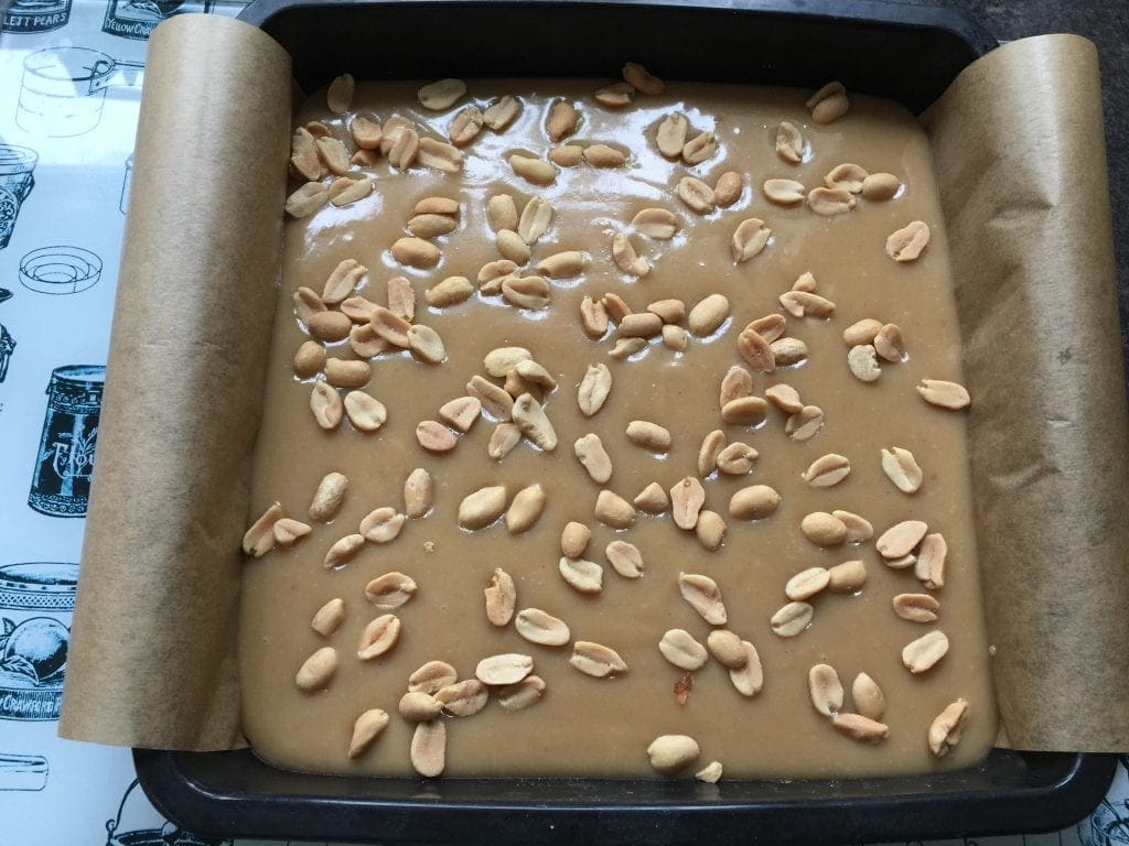 Caramel layer sprinkled with peanuts.
