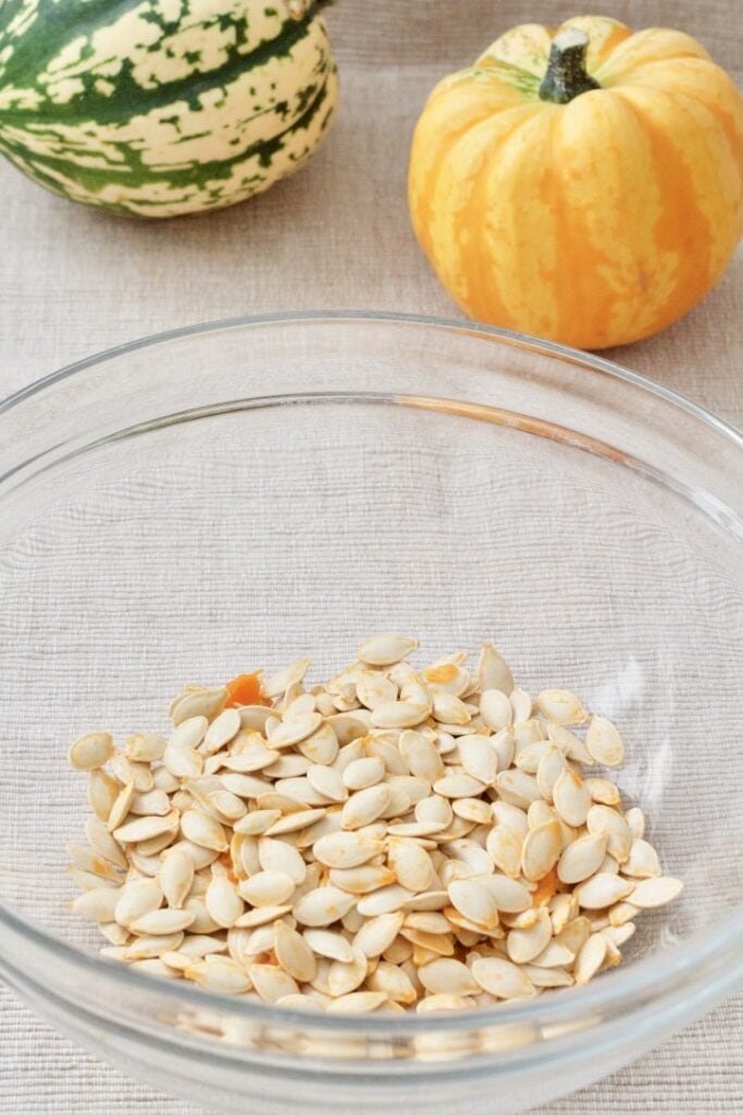 Raw pumpkin seeds in a bowl.