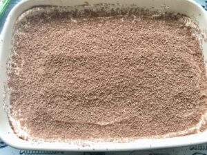 Easy Eggless Tiramisu - grating of chocolate on the first layer of mascarpone cream