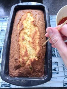 Making holes in a cake with a skewer.