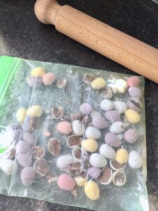 White Chocolate Blondies with Mini Eggs - Mini Eggs in a plastic bag bashed with rolling pin