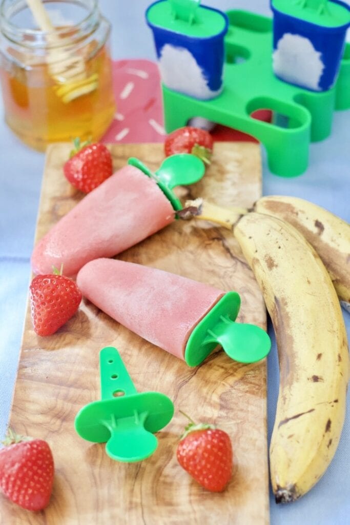 Ice lollies on a wooden board.