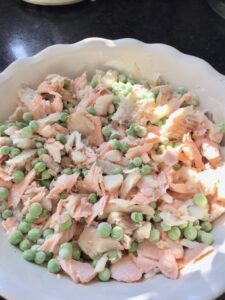 Poached fish and frozen peas in a pie dish.