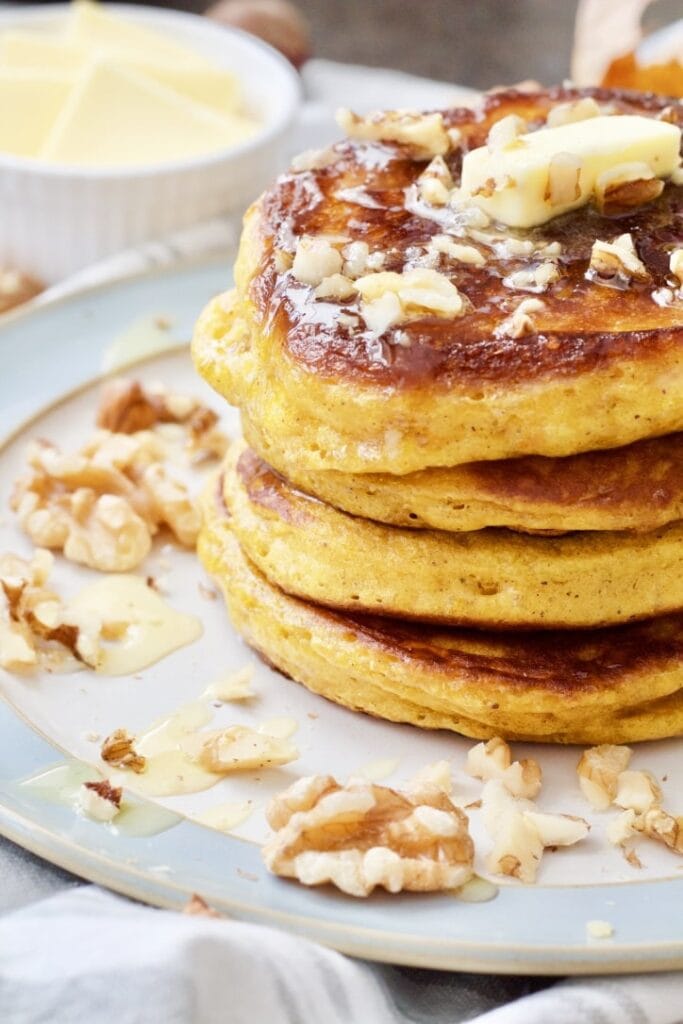 Stack of pumpkin pancakes with walnuts & butter.