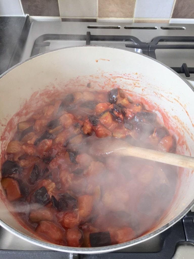Plums simmering in a pot.