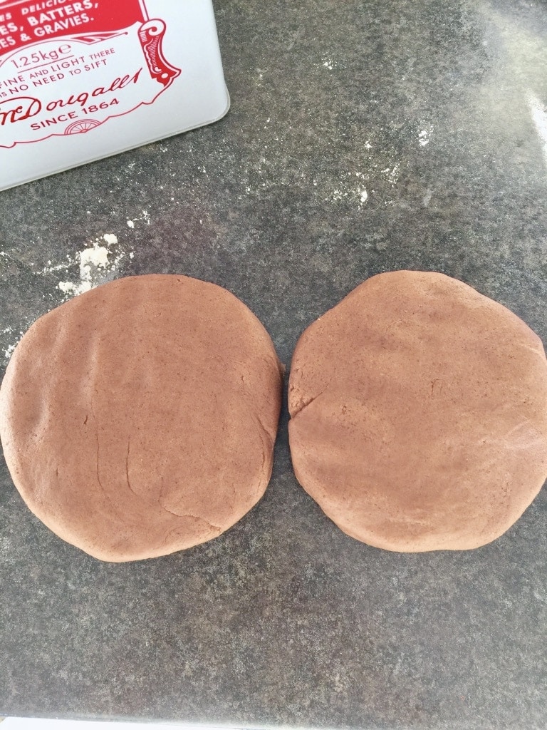 Two discs of gingerbread dough on the counter.