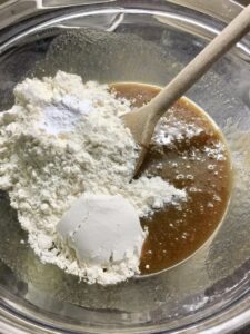 Sugar & butter mix with dry ingredients in a bowl.