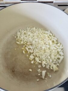 Sautéing some chopped onions in a pot.