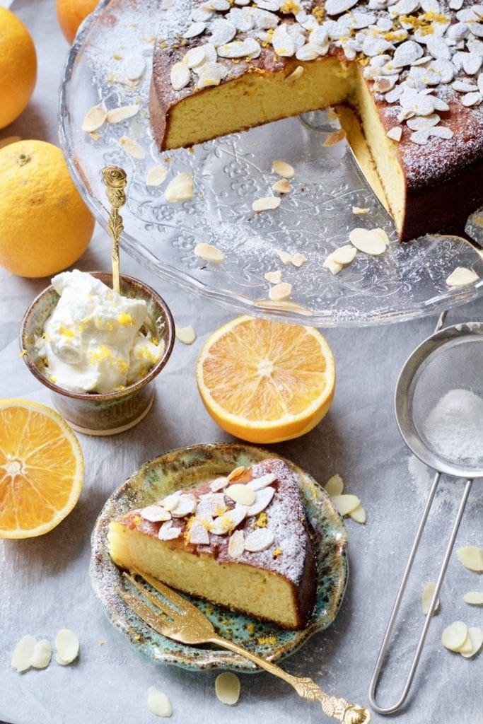 Gluten-Free Orange and Almond Cake sliced on a plate and cake on a stand