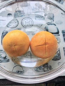 Gluten-Free Orange and Almond Cake - two oranges in a glass bowl half filled with water ready for microwaving