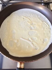 Pancake frying on a pan.