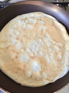 Pancake frying on the pan (other side).