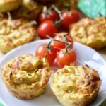 Cheesy Carrot & Courgette Savoury Muffins on a plate with cherry tomatoes