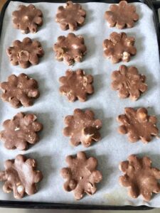 chocolate shortbread flower shaped cookies on baking tray