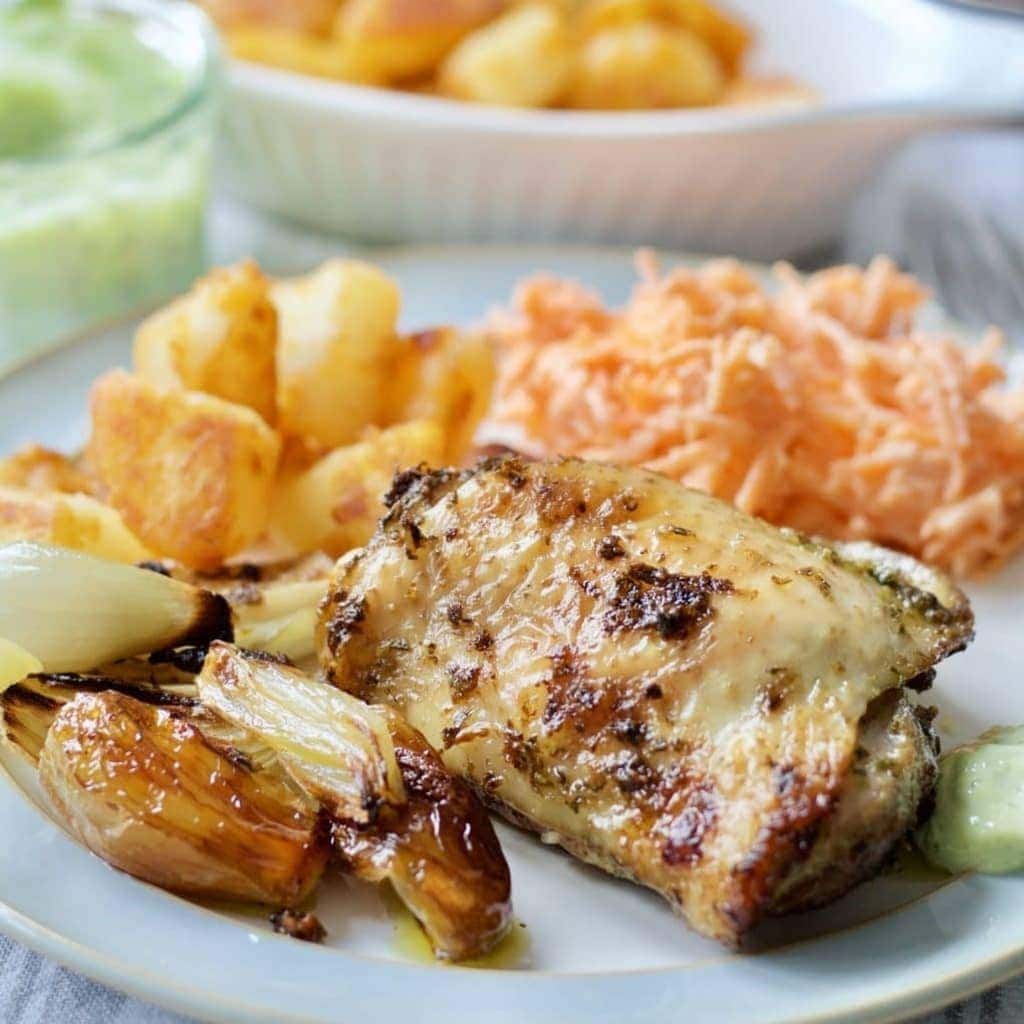 Plate with roasted chicken thigh, shallots, carrots & sautéed potatoes