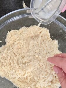 water being added to bowl with flour and cheese