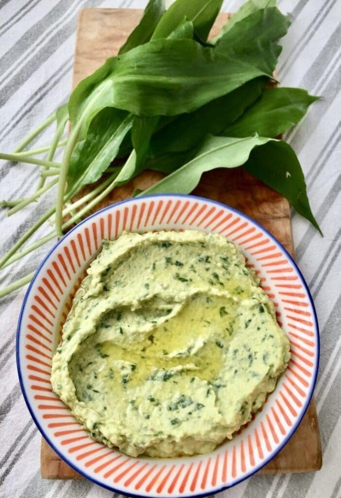 Wild Garlic Hummus in a bowl with fresh wild garlic