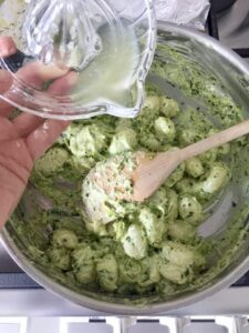 Lemon juice being added to gnocchi pesto mixture