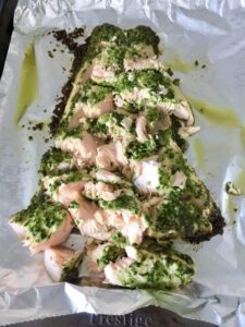 Baked pesto salmon flaked into pieces