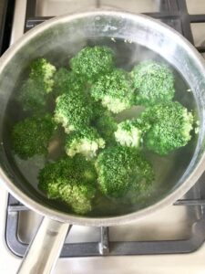 Broccoli florets in a pan of boiling water