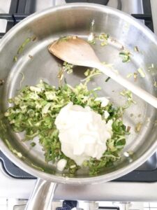 Pan fried leeks in a pan with Creme Fraiche and wooden spoon