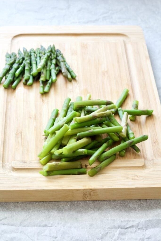 Asparagus pieces on a chopping board,