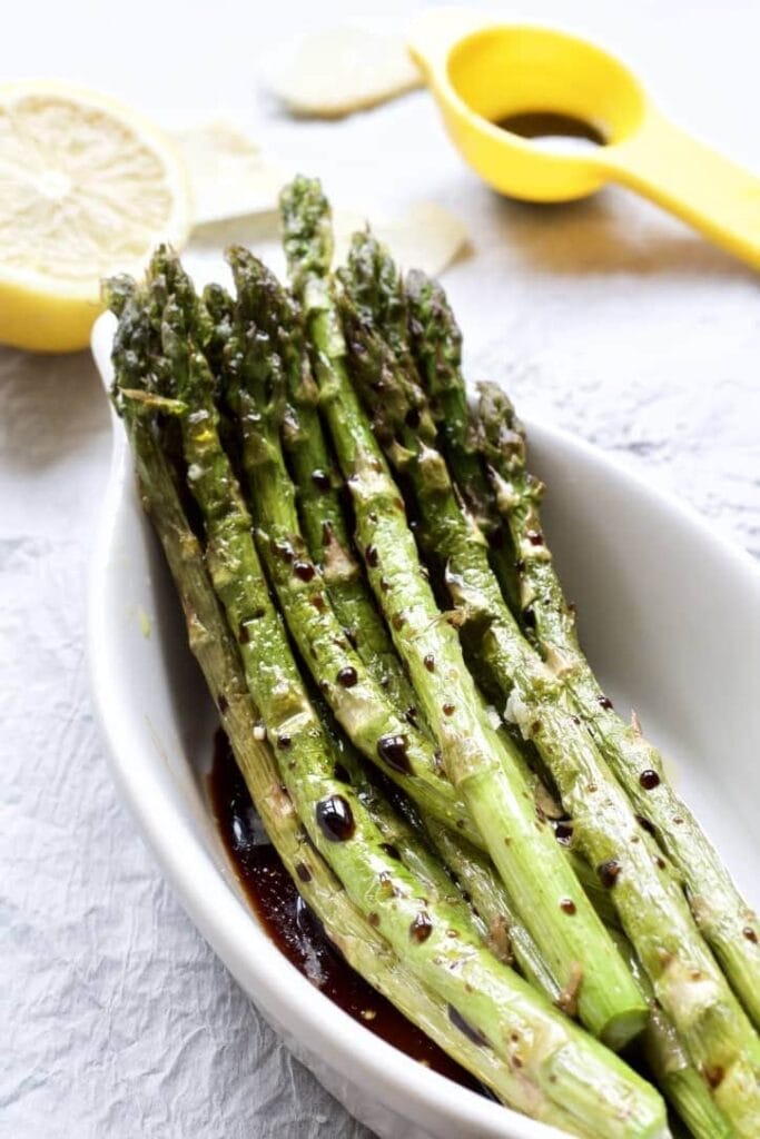 roasted asparagus in a dish with balsamic vinegar