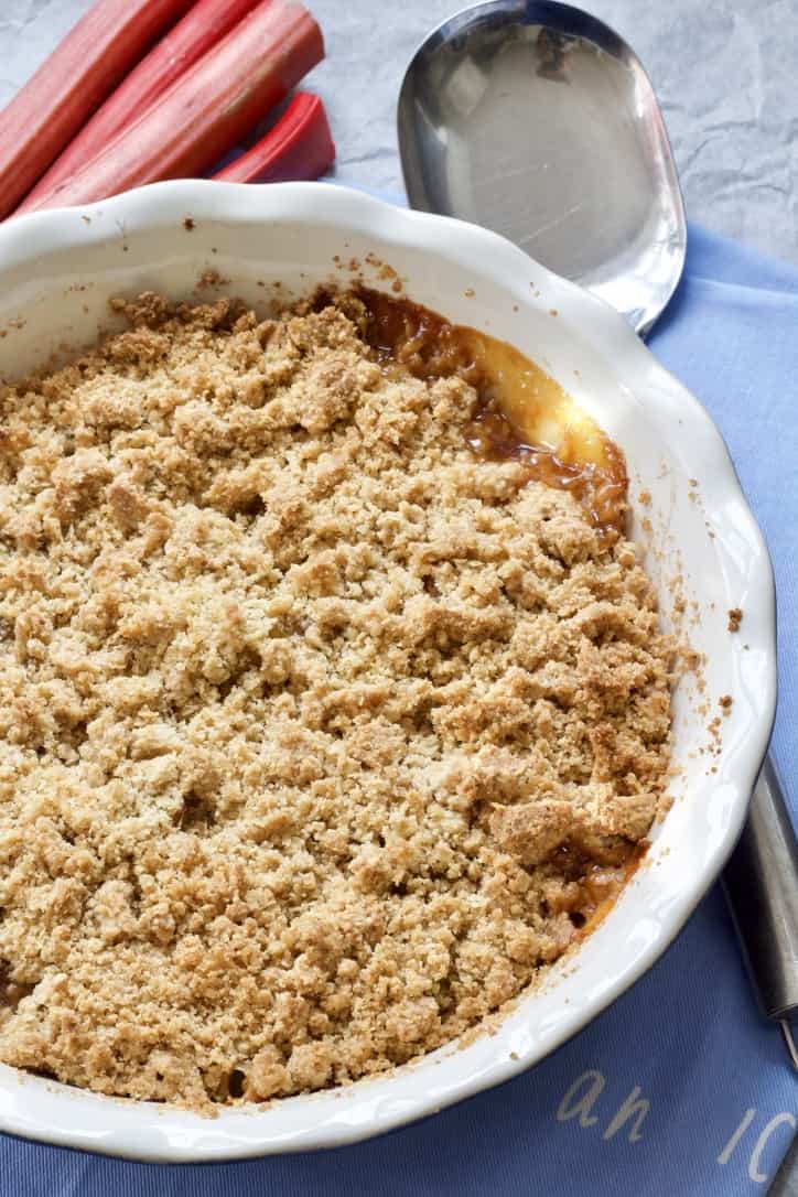 Rhubarb crumble in a dish with serving spoon.