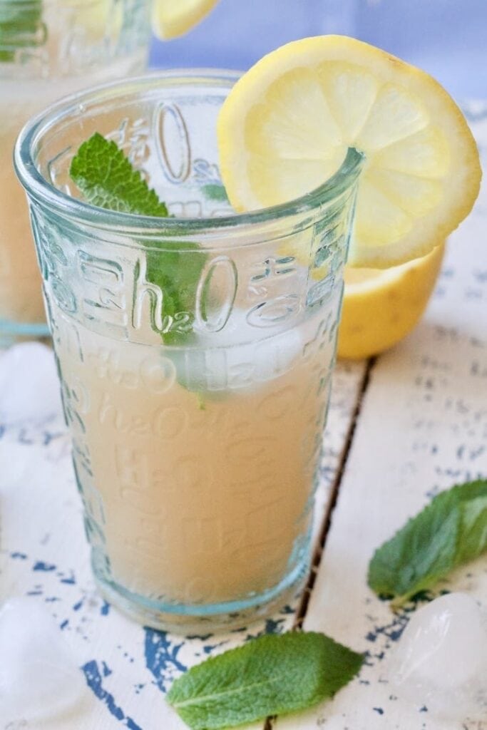 Rhubarb drink in a glass with mint & lemon.