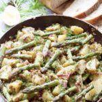Salad in a pan with asparagus tips on top.