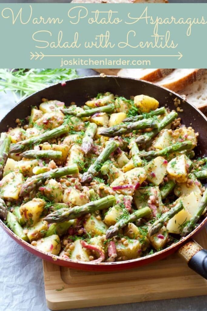 Salad in a pan with asparagus tips on top.