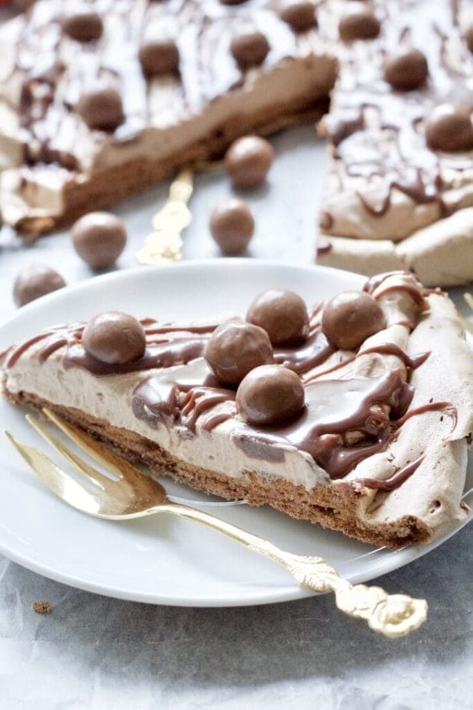 Slice of chocolate pavlova on a plate with a fork.