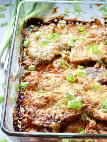 Oven baked pork chops in a baking dish.