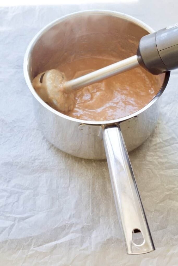 Rhubarb puree in a saucepan with stick blender.