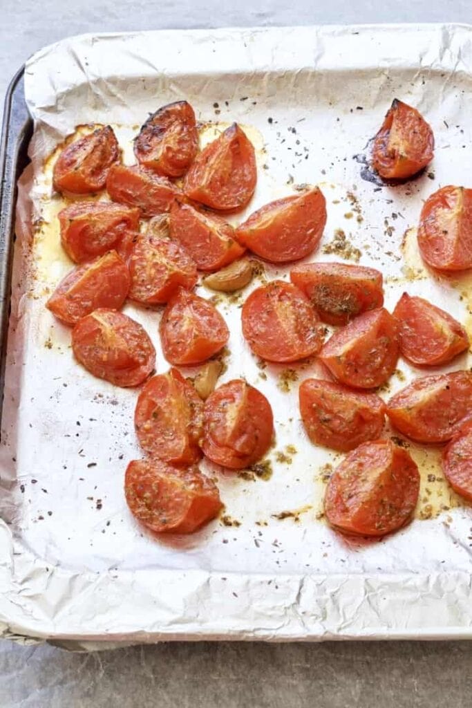 Roasted tomatoes on a baking tray.