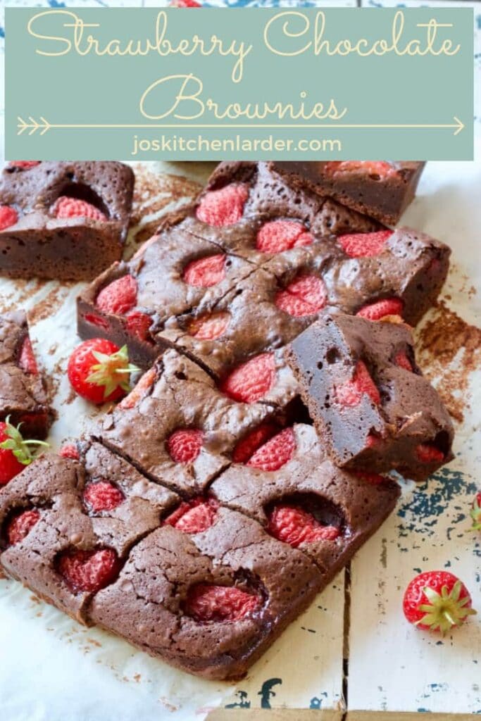 Strawberry brownies on a board with fresh strawberries.