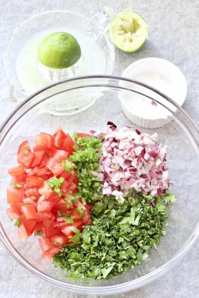 Chopped tomato salsa ingredients in a bowl.