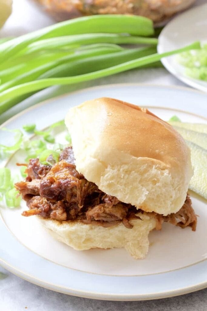 BBQ pulled pork in a bun with top tilted.