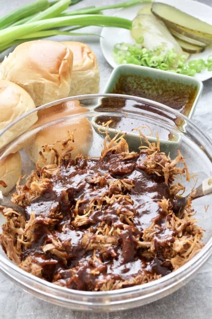 Shredded pork in a bowl covered with sauce.