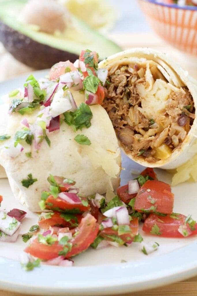 Close up of burrito cut in half with salsa.