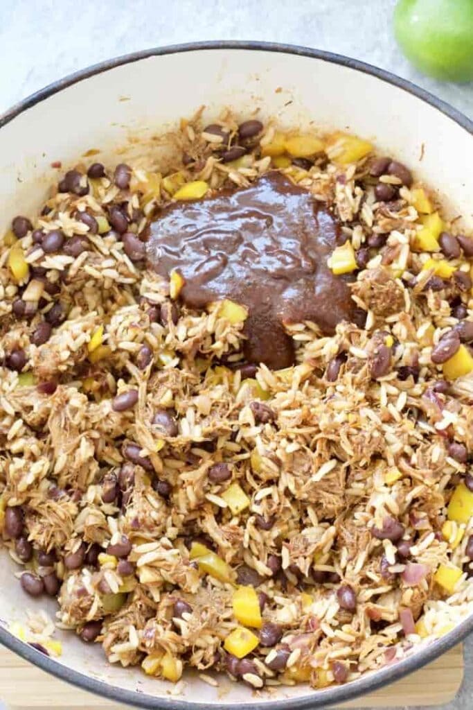 Burrito filling in a pan with a dollop of BBQ sauce.