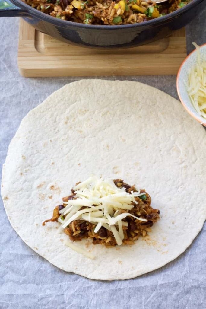 Tortilla with burrito filling and cheese.