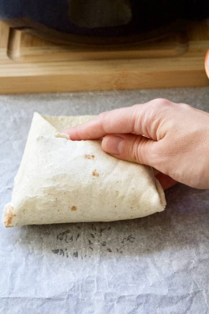 Hand finishing to fold a burrito.