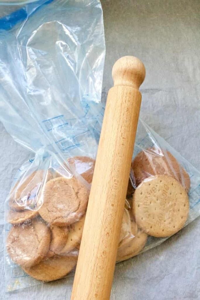 Biscuits in a bag being bashed with a rolling pin.