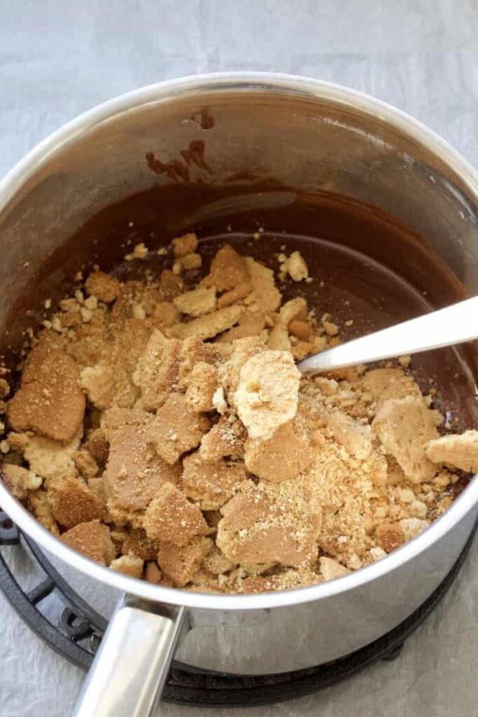 Crushed biscuits in a pan with chocolate.
