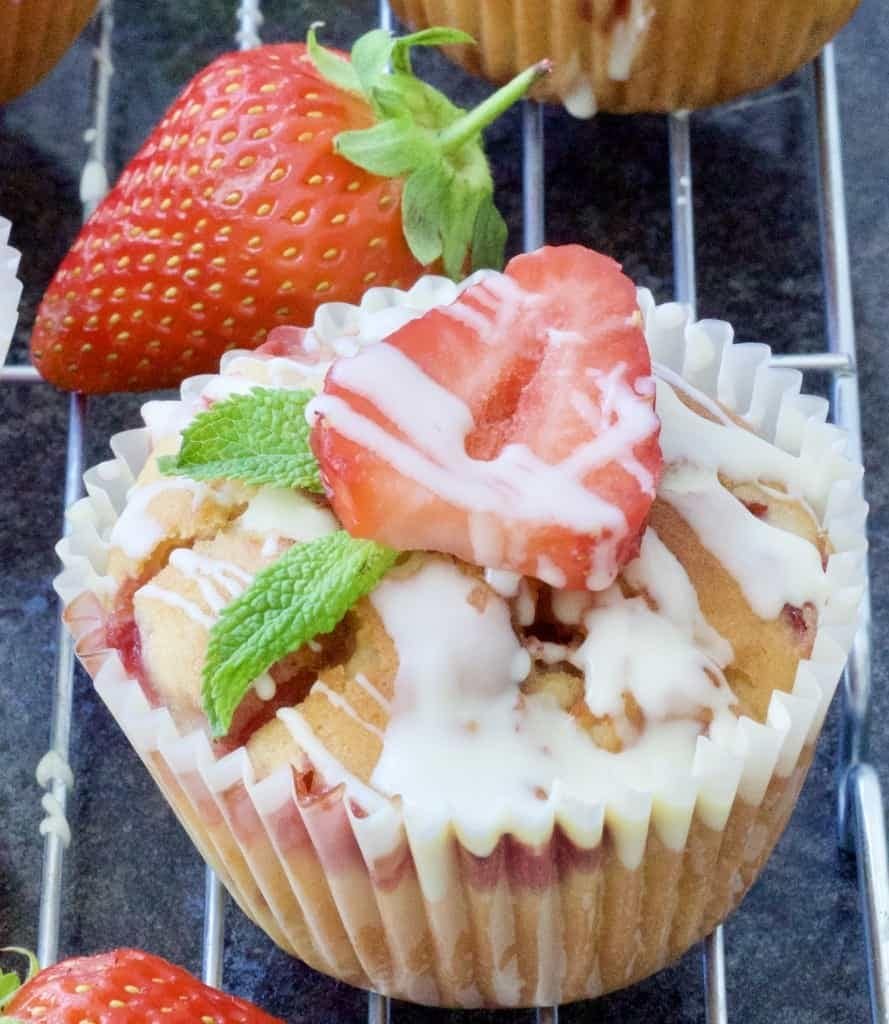 Strawberry muffin with sliced strawberry & mint leaves.