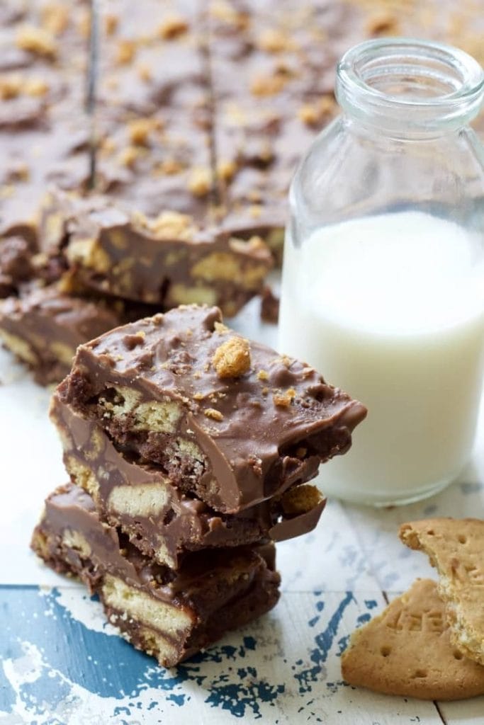 Stack of rocky road squares with bottle of milk.