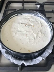 Stem ginger cheesecake in a round cake tin.